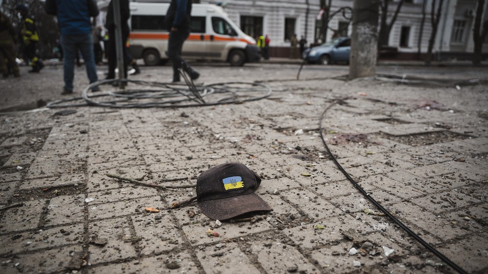 A cap with the Ukrainian flag and coat of arms on a city street