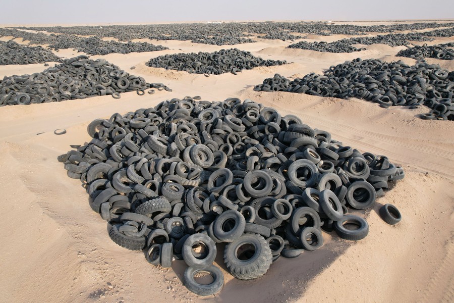 Thousands of discarded rubber tires sit in piles in the desert.