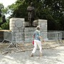 A woman with a cane walks past the J Marion Sims statue in New York's Central Park.