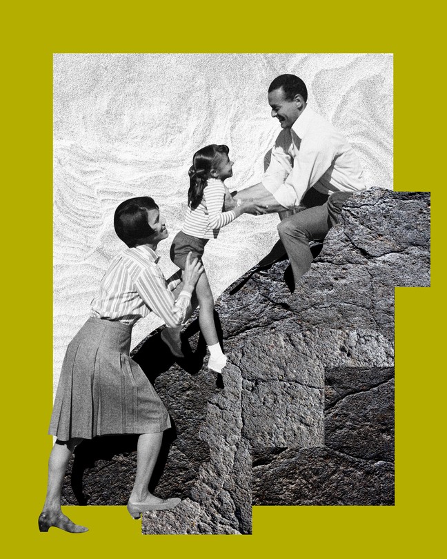 Photo of a mother and a father helping their daughter climb a rock