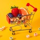 A miniature cart holding fruit slices and colorful cereal