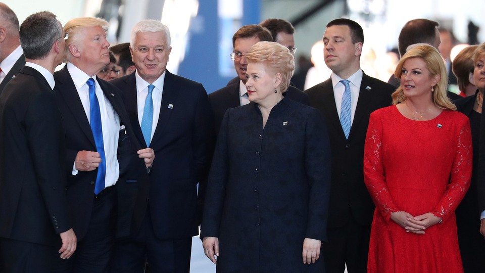 Trump adjusts his jacket after pushing in front of Marković and other world leaders. 