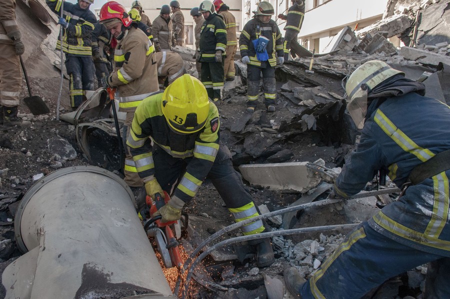 Rescue workers make efforts to clear rubble from a destroyed building.