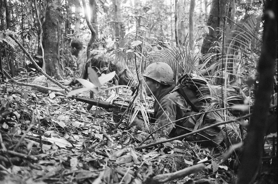 Picture of US marines hugging the ground, with one of their M16 rifle alert, after being fired upon by an undetermined number of North Vietnamese soldiers in the jungle in South Vietnam, April 22, 1969. 