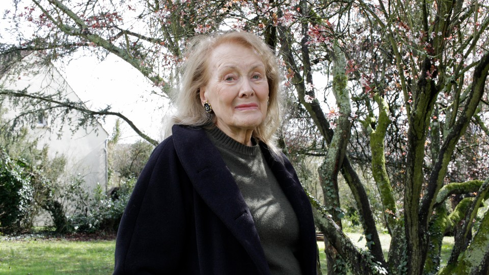 A photograph of Annie Ernaux in front of a tree