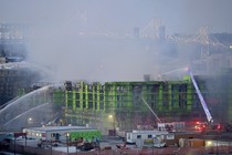 Firefighters spray water on a burning, partially completed apartment building in the San Francisco Bay Area.