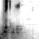 A ghostly presence coming out of a door in a house