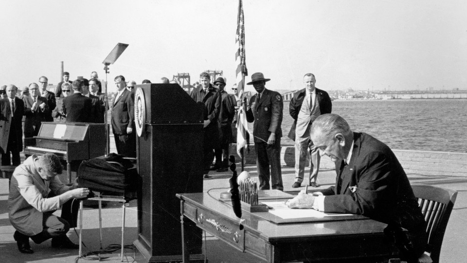 President Lyndon B. Johnson signs the new immigration bill on Liberty Island in New York Harbor.