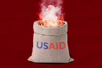 Illustration of a sack labeled "USAID" on fire against a red background