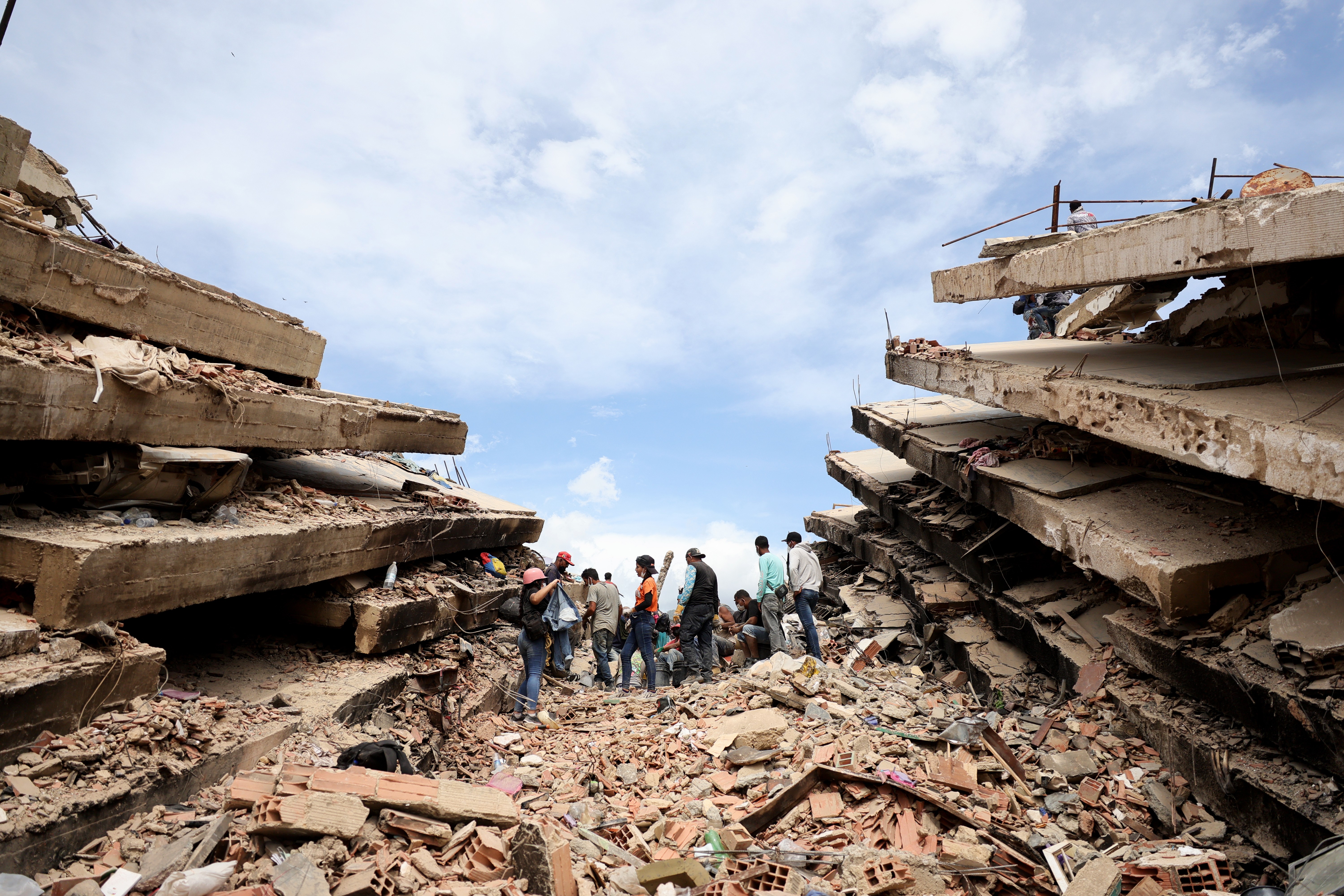 Rescuers work in the rubble of collapsed buildings.