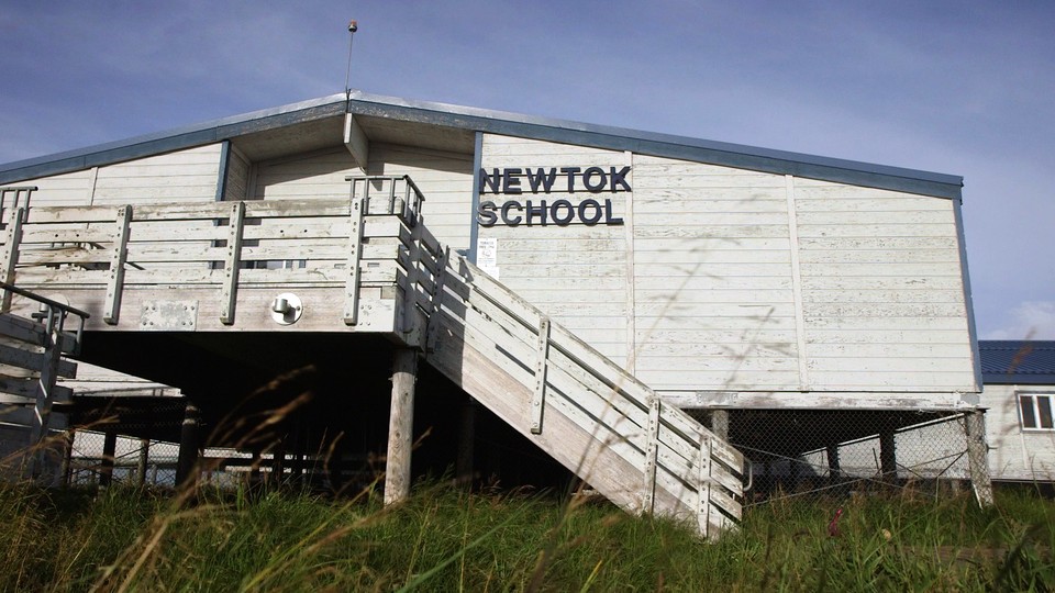 Newtok School is white and sits on risers about eight feet above the ground.