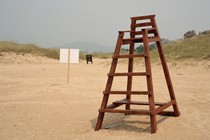 Photo of an empty lifeguard chair on a beach