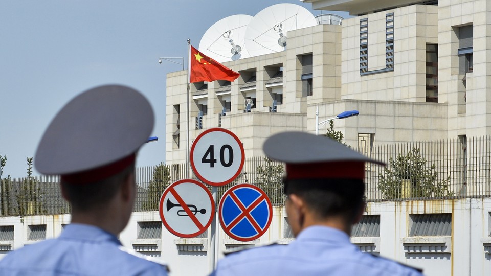 Kyrgyz police officers look at the Chinese Embassy after a suicide bombing in Bishkek, Kyrgyzstan.