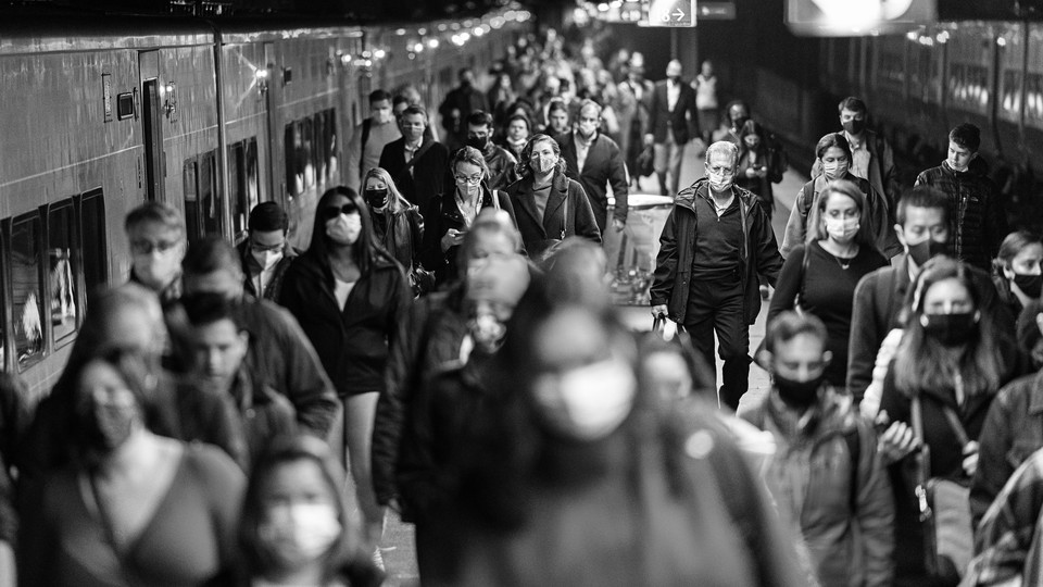 A black-and-white photo of commuters leaving a train in a station in New York City