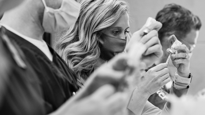 Health care workers administer vaccines