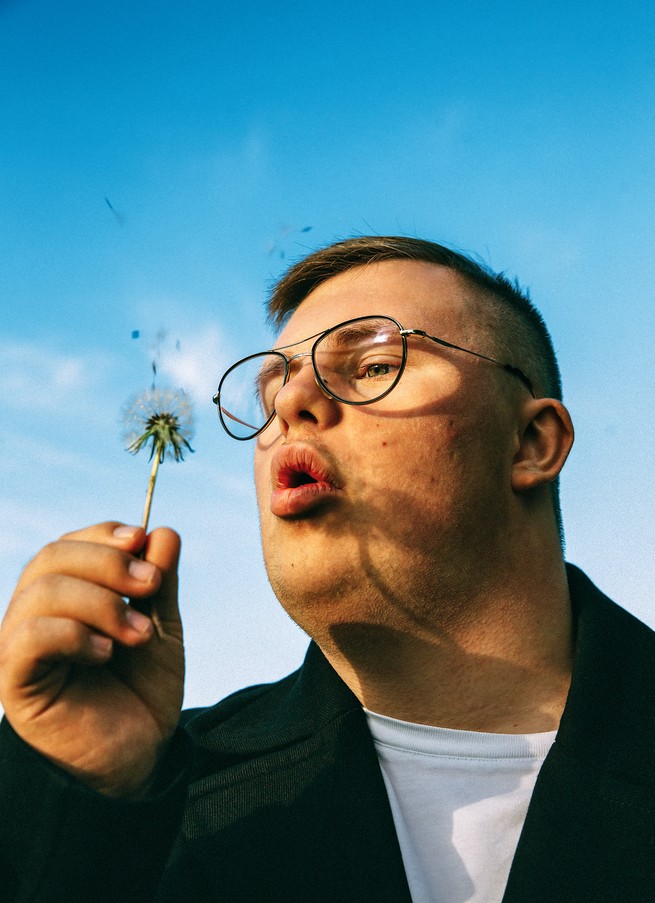 Karl Emil Fält-Hansen blows seeds from a dandelion