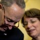 Senate Minority Leader Chuck Schumer and Senator Amy Klobuchar speak together during a news conference.