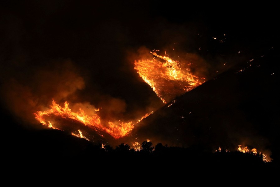 A nighttime view of a wildfire burning on a hillside