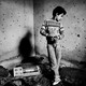 A black-and-white photo of a Palestinian boy in Gaza