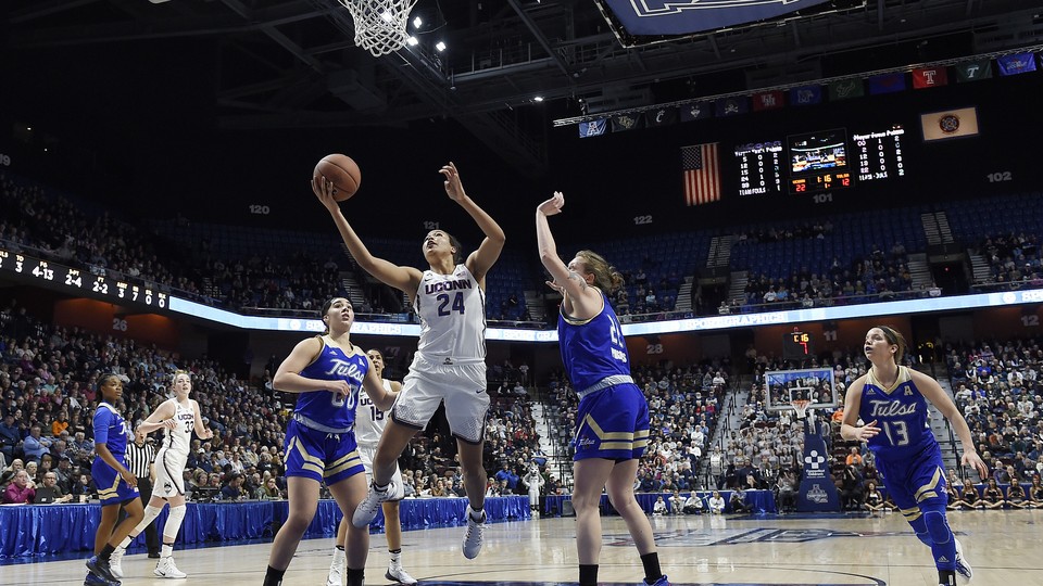 Connecticut's Napheesa Collier, center, splits Tulsa's defense during the first half of an NCAA college basketball game in the American Athletic Conference tournament quarterfinals.