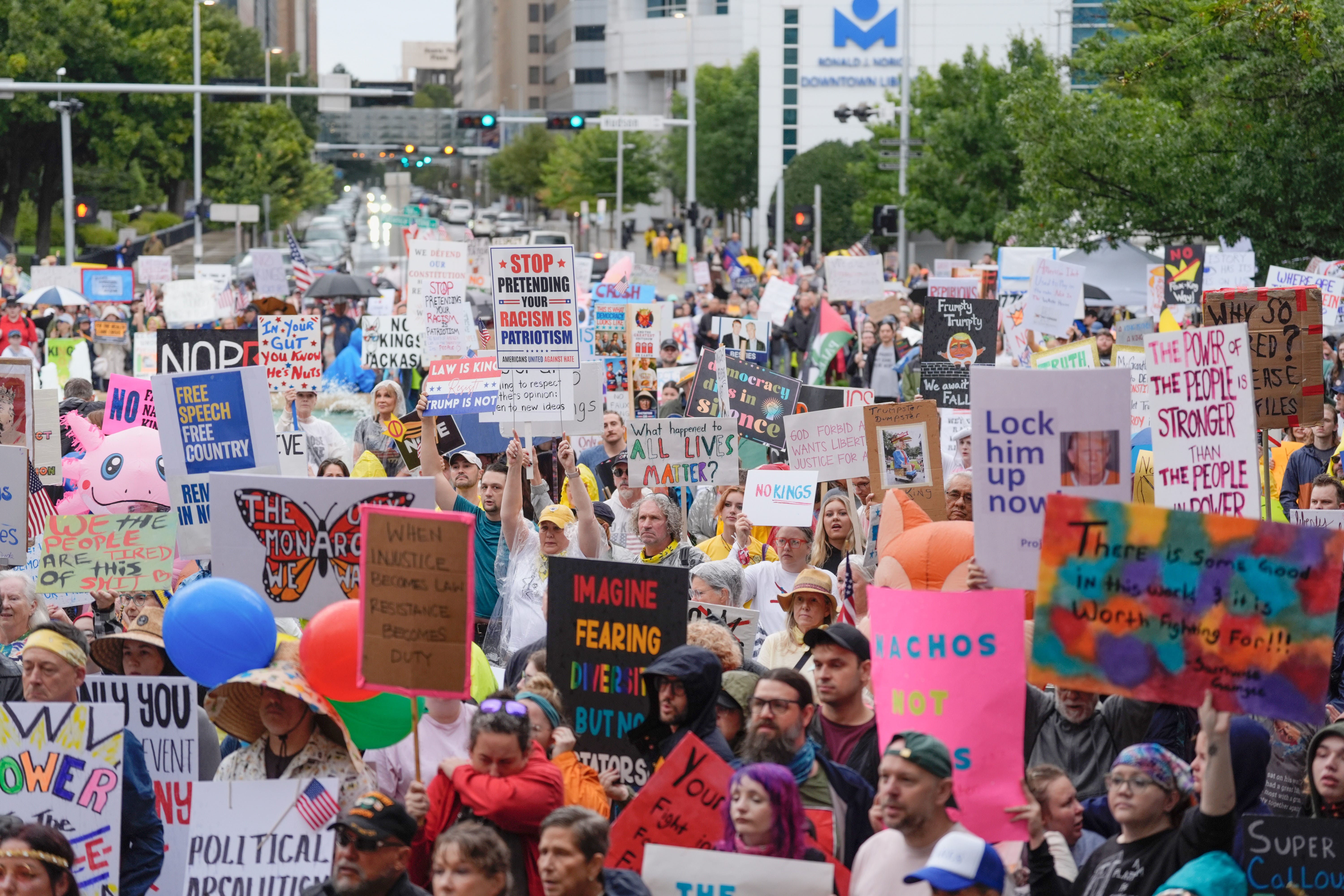 A large crowd of protesters hold signs in a street in Oklahoma City.