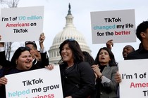 An image of people holding pro-TikTok signs in front of the Capitol