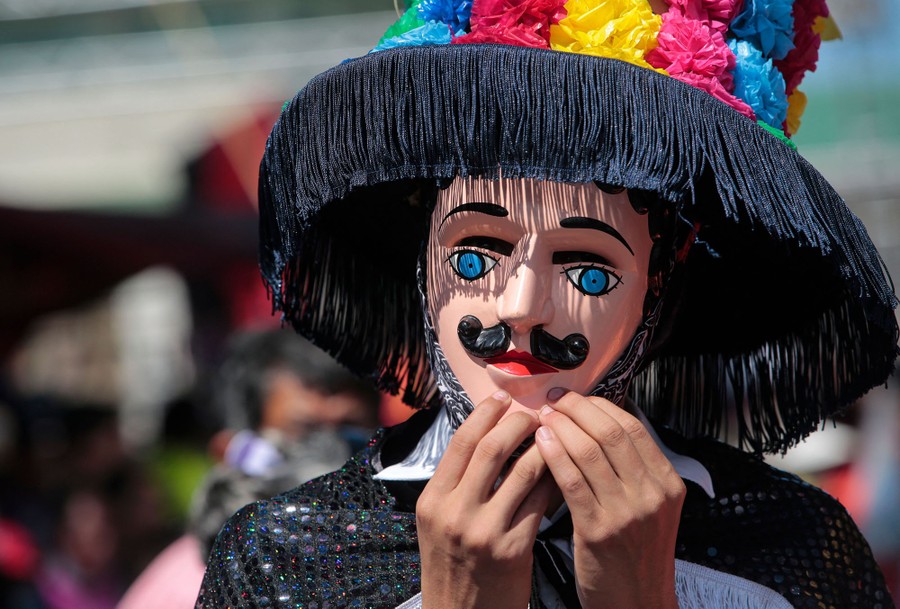 A person is pictured wearing a traditional costume and mask.