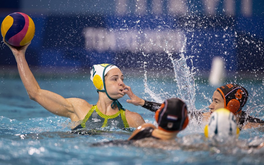 A water-polo player snags another player's lip with their finger during a game.