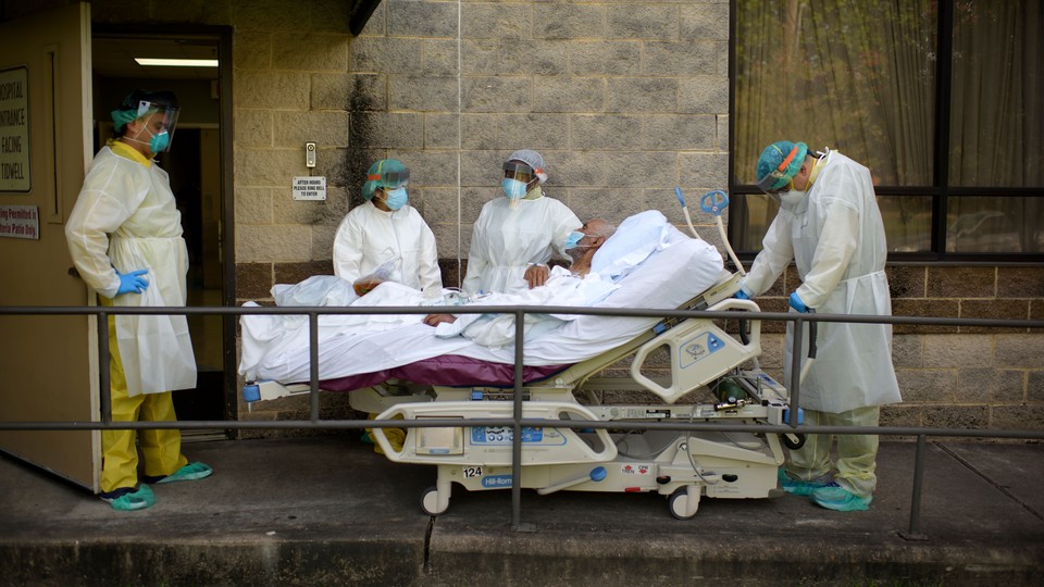 Health-care workers transfer a patient out of the COVID-19 Unit at United Memorial Medical Center in Houston, Texas, during a summer explosion of coronavirus cases.