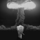 A photo-illustration of an elephant walking toward a nuclear detonation
