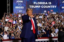 Donald Trump in a red tie and blue suit at a Florida rally