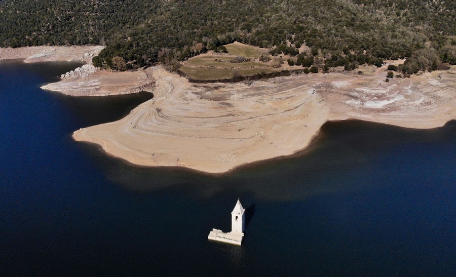 A partially-submerged church is seen in a low reservoir.
