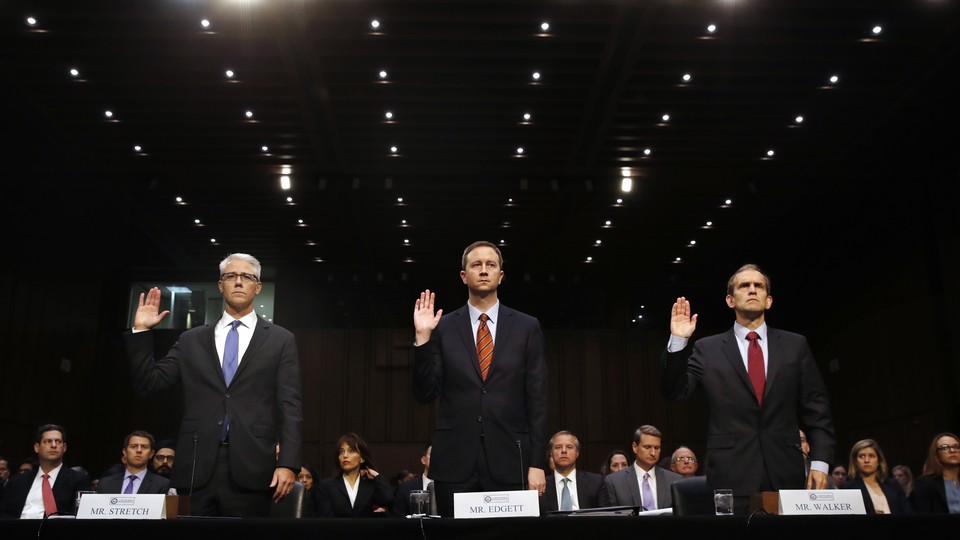Three representatives, of Google, Facebook, and Twitter, stand with their right hands raised to be sworn in for the Senate Intelligence Committee hearing on Russia's election activity