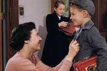 A mother sending children off to school