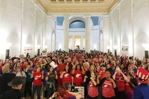 West Virginia teachers in red shirts cheer in the state Capitol after a deal was reached to end their strike. 