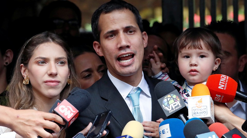 Juan Guaidó talks to members of the press with his wife and daughter outside their home.
