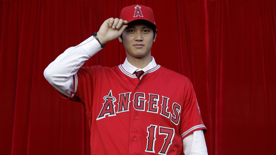 Baseball player Shohei Ohtani poses for photos after a news conference at Angel Stadium