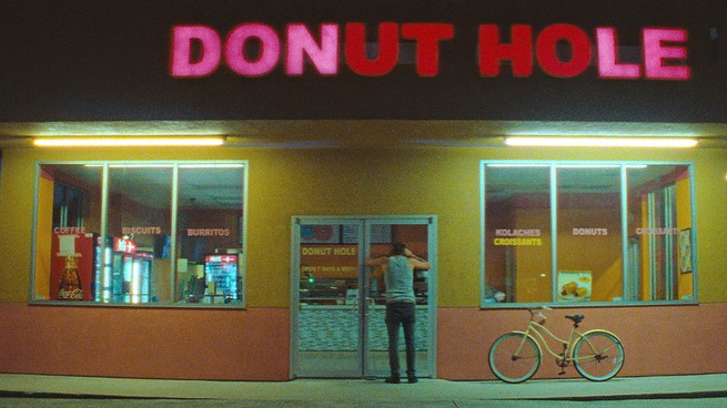 Simon Rex peers into the doorway of a doughnut shop in "Red Rocket"