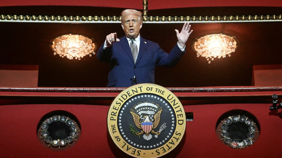 President Donald Trump stands and points in the presidential box as he tours the John F. Kennedy Center