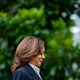 Kamala Harris smiles while looking down and walking