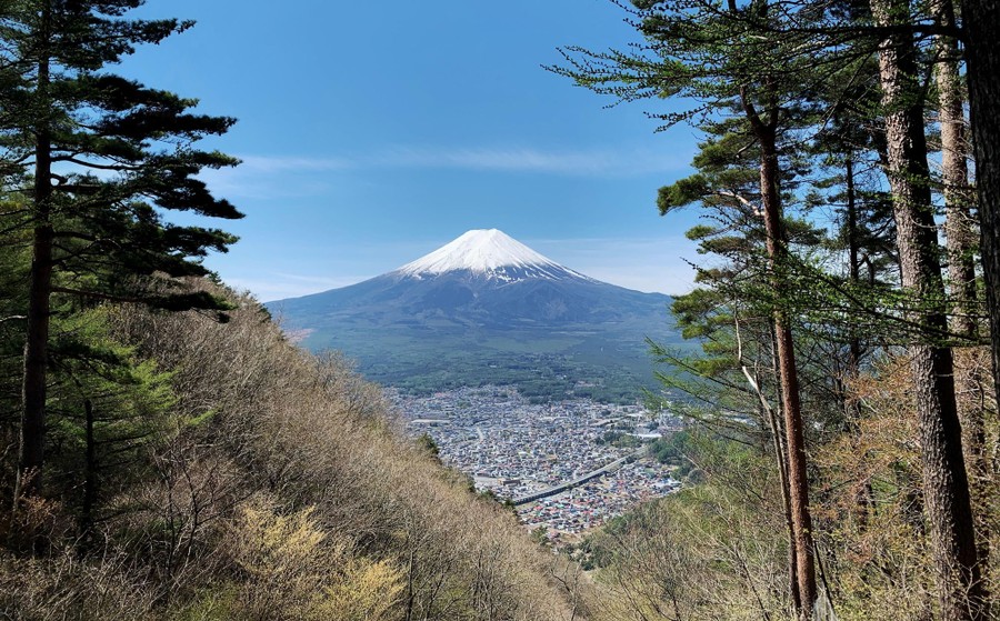 A view of Mount Fuji, seen beyond a small city.