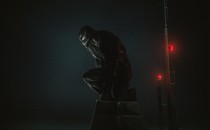 Venom kneels in darkness in "Venom: Let There Be Carnage."
