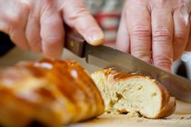 Joan Nathan cuts pain petri, a flavored challah.