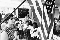 A teacher and her schoolchildren pledging allegiance to the American flag