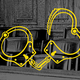 Yellow outline of unlocked handcuffs over a black and white picture of an empty jury box