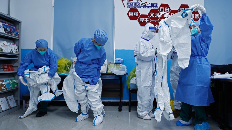 Medical workers put on protective suits.