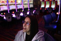 A woman wearing glasses looks up at a screen