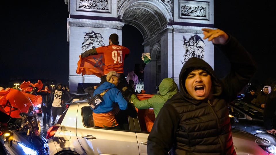 Morocco fans celebrate the team's defeat of Portugal in front of the Arc de Triomphe, in Paris.
