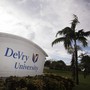 A sign reading "DeVry University" sits next to a palm tree in Florida.