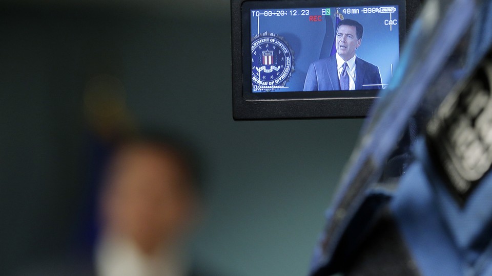 Cameras record former FBI Director James Comey during a news conference in Boston, Massachusetts on November 18, 2014. 